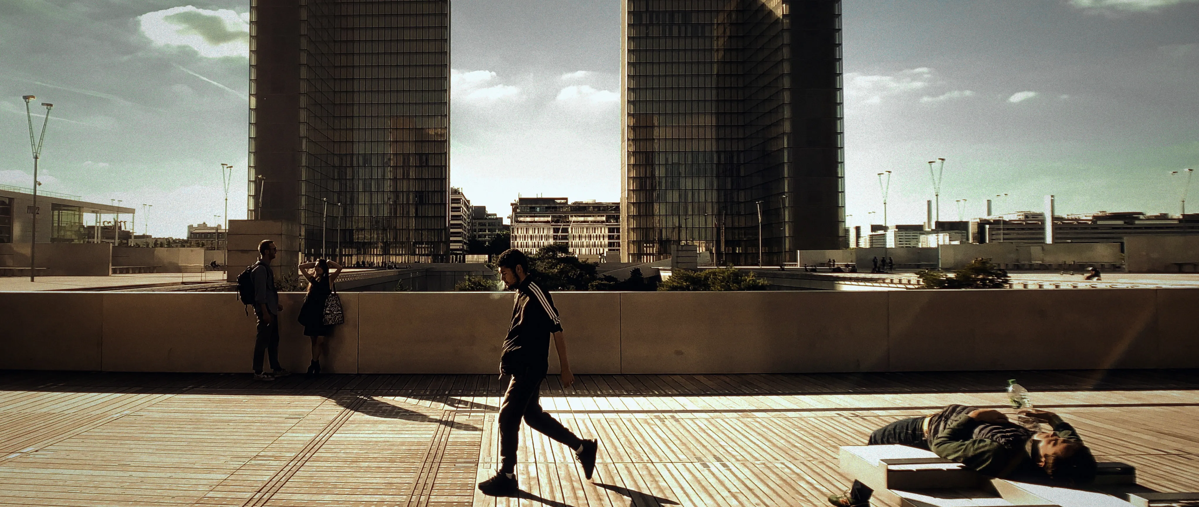 Un soir ensoleillé, un jeune homme marche au cœur de la BNF (Paris 13eme)
